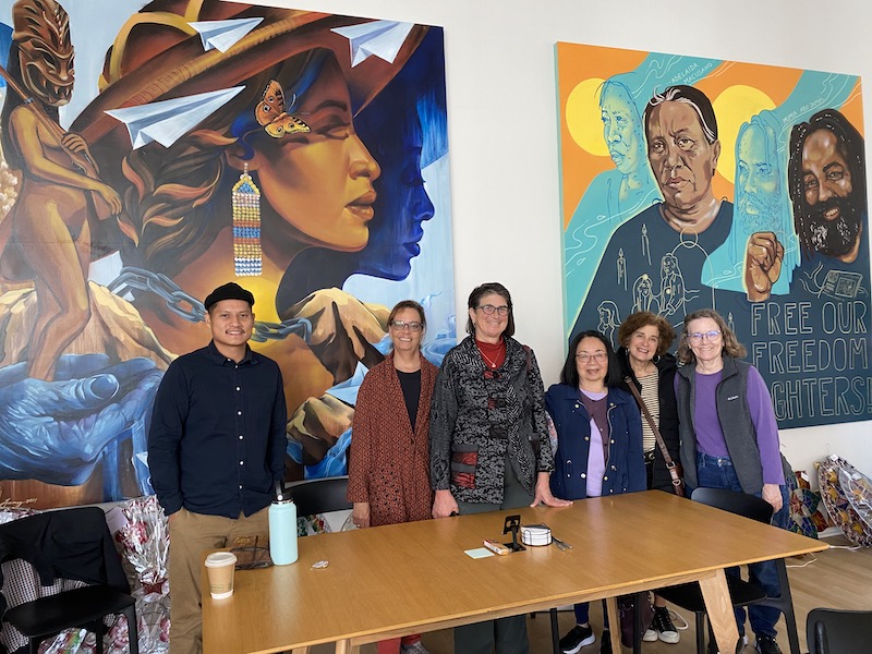 OLLI members and tour guide posing in front of mural