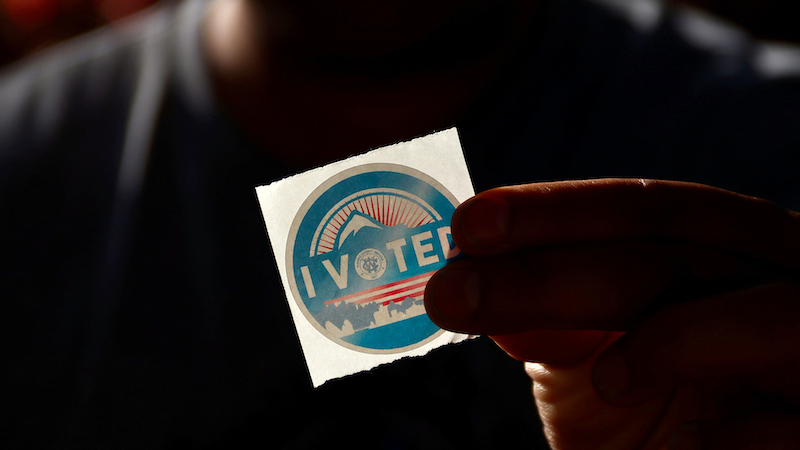 A hand holding an "I Voted" Sticker