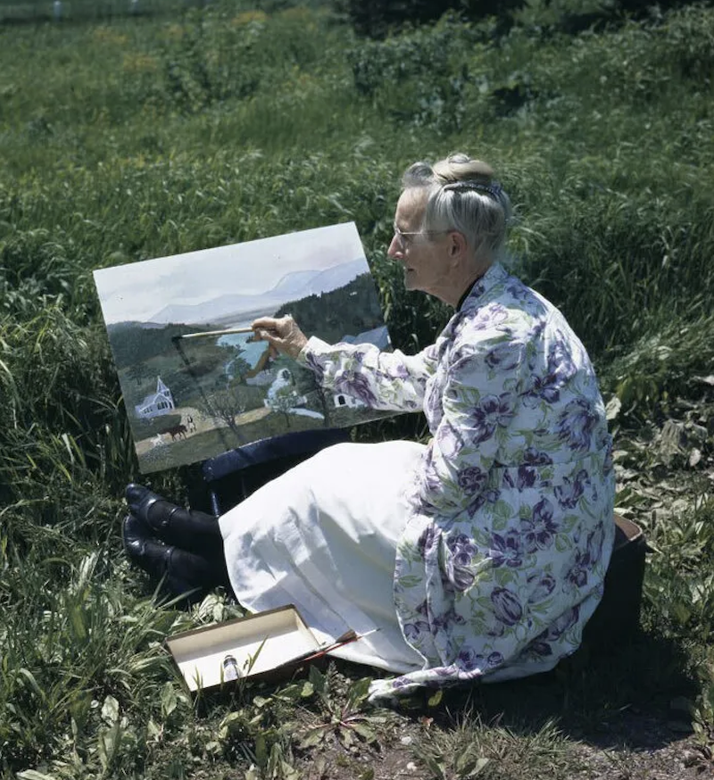 "old woman painting in field"