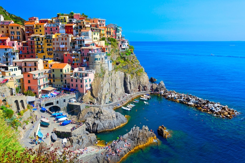 Colorful houses in Portofino dotting a mountaintop alongside a lake